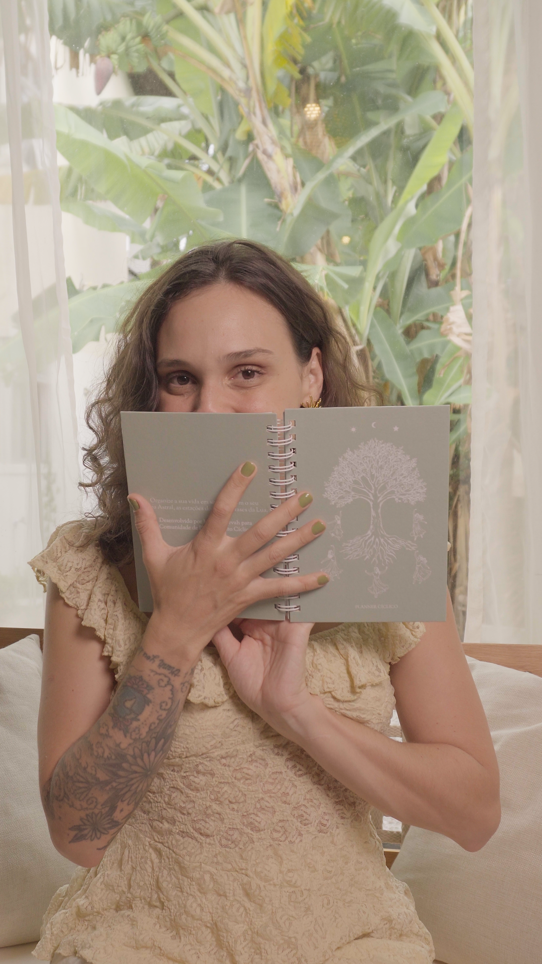 Mulher com o planner aberto em frente ao rosto